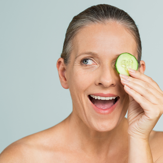 Woman holding cucumber slice - Developing fine lines and wrinkles on forehead, Prescription- Dermatologist's Choice