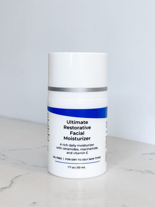 Bottle of  Ultimate Restorative Facial Moisturizer on a marble surface with a white background, best post peel moisturizer with vitamin e, ceramides, niacinamide, oil-free so great for sensitive and acne prone skin