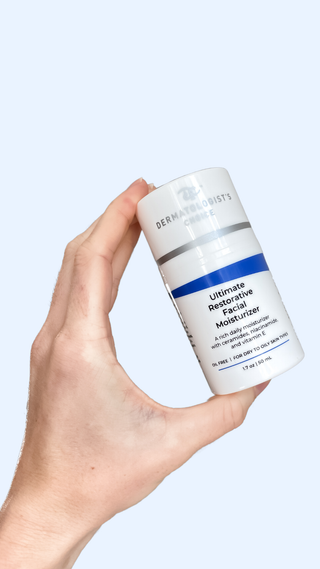 Person holding a Bottle of  Ultimate Restorative Facial Moisturizer on a marble surface with a white background, best post peel moisturizer with vitamin e, ceramides, niacinamide, oil-free so great for sensitive and acne prone skin from Dermatologist's Choice Skincare - Skin Care Developed by Dr. B a board-certified Dermatologist with over 50 years of experience