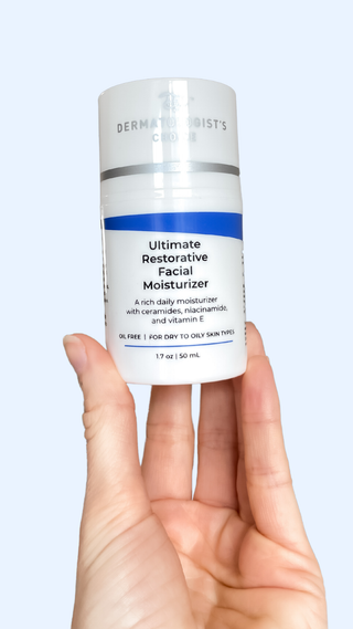 Person holding Bottle of Ultimate Restorative Facial Moisturizer on a marble surface with a white background, best moisturizer to use after a chemical peel with vitamin e, ceramides, niacinamide, oil-free so great for sensitive and acne prone skin from Dermatologist's Choice Skincare - Skin Care Developed by Dr. B a board-certified Dermatologist with over 50 years of experience great compliment to active ingredients like tretinoin, glycolic acid, and tca